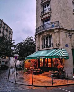 a building with a green awning next to a street