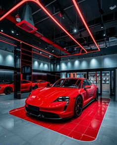 two red sports cars in a showroom with neon lights on the ceiling and floor