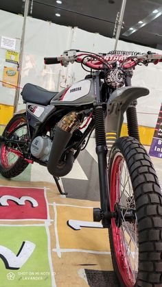 a motorbike is parked on display in a showroom with red rims