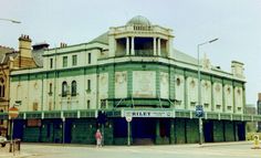 an old building with people walking in front of it