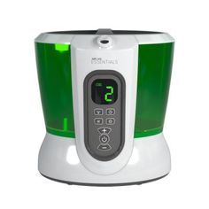 a green and white blender sitting on top of a white table next to a clock