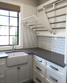 an empty kitchen with white cabinets and black counter tops is pictured in this image, there is a window above the sink