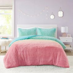 a pink and blue bed in a bedroom