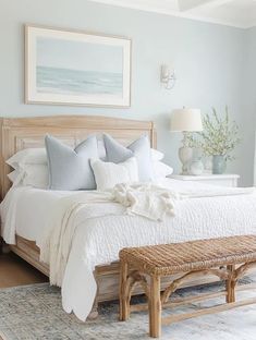 a bedroom with a bed, bench and pictures on the wall above it that is decorated in neutral colors