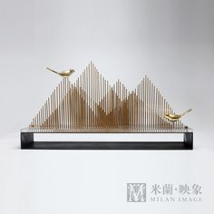 two birds sitting on top of a wooden structure with metal strips in the shape of mountains