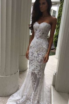 a woman in a wedding dress standing outside