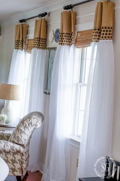 a living room with white curtains and a chair