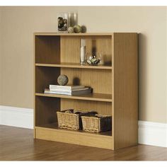 a wooden book shelf with baskets and books on it's sides, against a beige wall