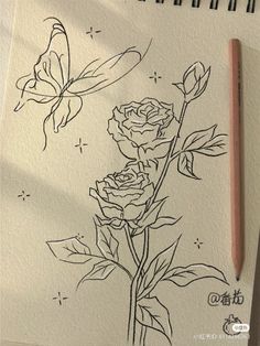 a drawing of two roses and a butterfly on a piece of paper next to a pencil