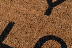 a door mat with the letter o on it and an arrow drawn in black ink