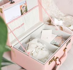 an open pink suitcase sitting on top of a table