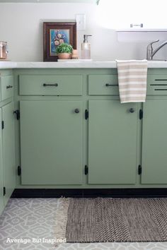 a kitchen with green cabinets and white counter tops