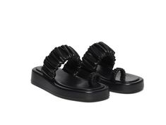 a pair of black shoes with ruffles on them