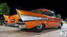 an orange and white classic car parked on the street