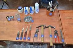 a table topped with lots of tools on top of a wooden table covered in writing