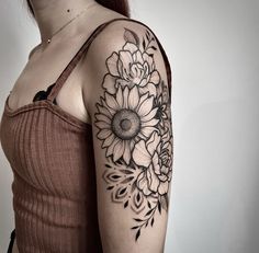 a woman's arm with a sunflower tattoo on the upper half of her arm