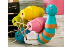 colorful toy snail sitting on top of a table next to a potted plant and other items