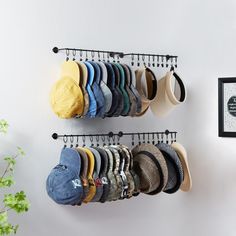 several hats are hanging on the wall next to a coat rack