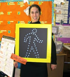 a woman holding up a sign with an arrow drawn on it in front of her