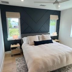 a large bed in a bedroom next to two windows