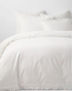 a bed with white sheets and pillows on it