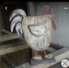 a wooden chicken statue sitting on top of a piece of wood