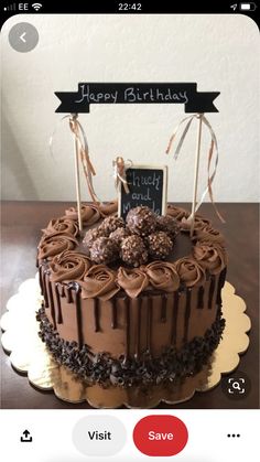 a birthday cake with chocolate frosting and candies on top, decorated with a sign that says happy birthday