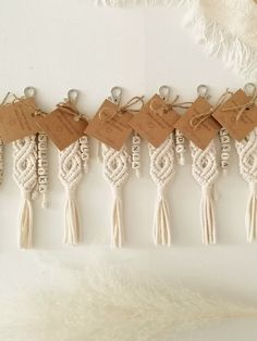 six macrame tassels with tags attached to them