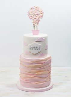 a three tiered cake with baby's breath on top and pink ruffles