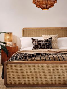 a bed with wicker headboard and pillows on top of it in a bedroom