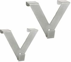 two metal brackets on the side of a white wall, one has a letter v