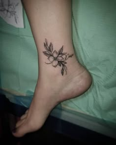 a woman's foot with a flower tattoo on it