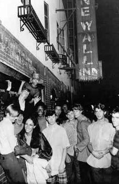 a group of people standing around each other in front of a building