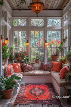 a sun room with lots of potted plants in the windows and rugs on the floor