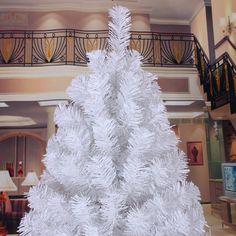 a fake white christmas tree in a lobby