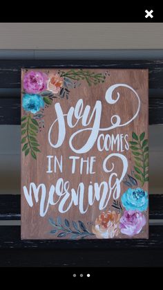 a wooden sign that says joy comes in the morning with flowers and leaves on it