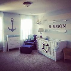 a baby's room with an anchor and name sign on the wall