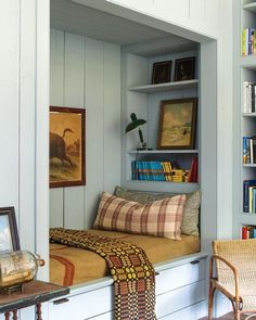 a room with a bed, chair and bookshelf filled with lots of books