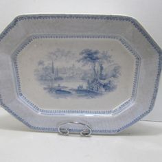 a blue and white plate with a landscape on it