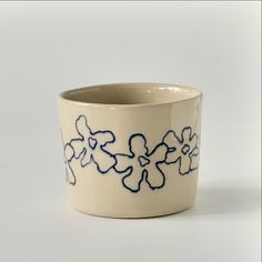 a white cup with blue flowers on it