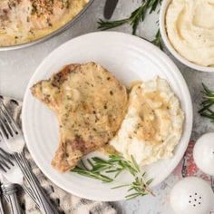 two white plates topped with mashed potatoes and meat