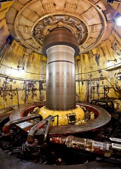 the inside of an old machine room with pipes and machinery in it's center