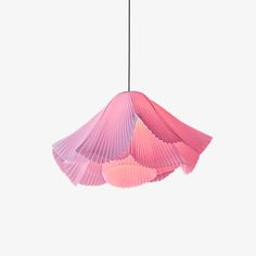 a pink lamp hanging from the ceiling with pleated shades on it's lampshade