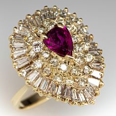 This captivating ring is centered with a pear mixed cut ruby, weighing 0.70 carats, in a three-prong setting. The center is surrounded by a total of twenty-six (26) prong set, round brilliant cut diamonds and thirty-two (32) prong set, tapered baguette cut diamonds. The ring measures 20.1mm at the top, rises 11.4mm above the finger, tapering to 2.3mm wide and 1.0mm thick at the base of the shank. This ring is currently a size 5.5. There is a tiny nick on the ruby but nothing distracting. Antique Ruby Ring, Vintage Cluster Ring, Diamond Cocktail Ring, Jewelry Luxury, Diamond Cocktail Rings, Baguette Cut Diamond, Ruby Jewelry, Ruby Diamond, Diamond Cluster Ring