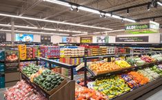 an aisle in a grocery store filled with lots of fresh fruits and veggies