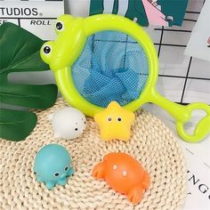 three plastic toys sitting on top of a table next to green leaves and a blue net