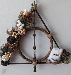 a christmas wreath hanging from the side of a wall with an owl decoration on it