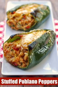 two stuffed peppers on a white plate with a red and white checkered tablecloth