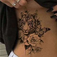 a woman's stomach with a tiger and roses tattoo on it, next to a butterfly