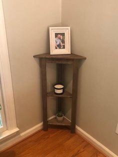 a small corner shelf with a framed photo on it